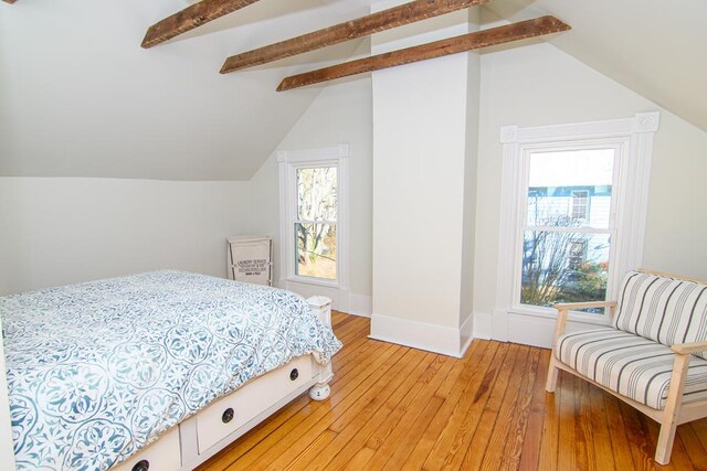 bedroom featuring hardwood / wood-style floors and lofted ceiling with beams