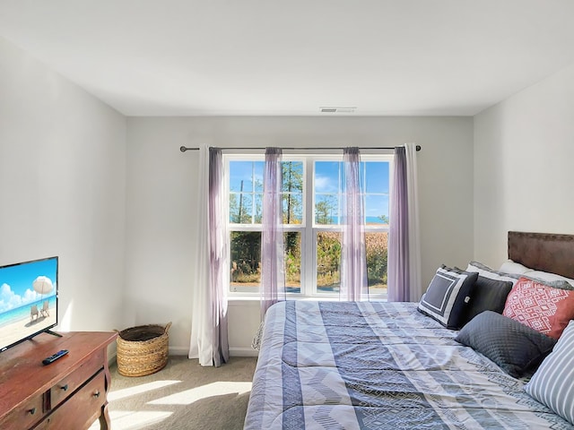 bedroom with light carpet and multiple windows