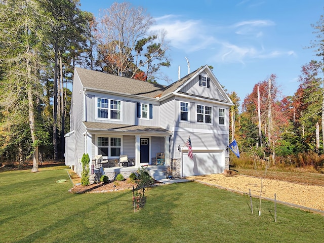 view of front of home with a front yard, a porch, and a garage