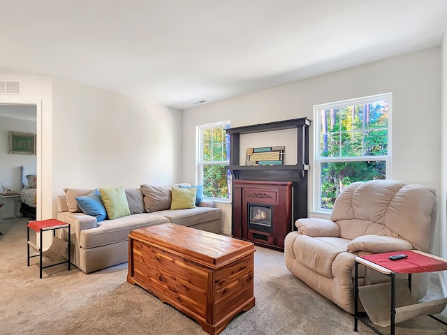 living room with light carpet, a fireplace, and a healthy amount of sunlight