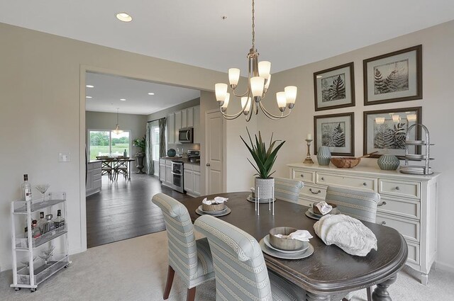 dining space with light colored carpet and an inviting chandelier