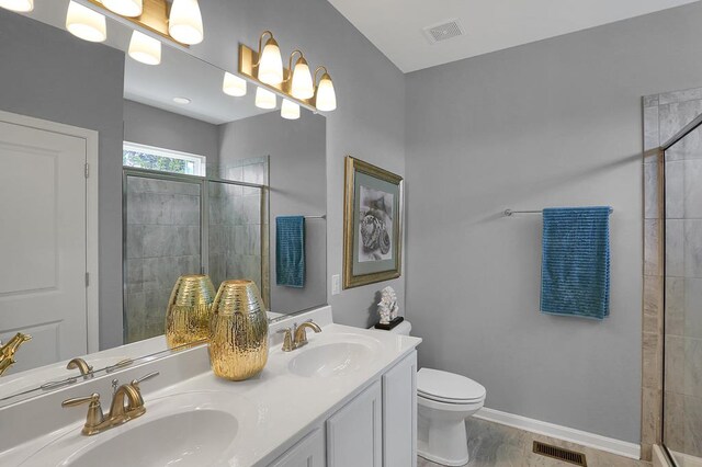 bathroom featuring a tile shower, vanity, and toilet