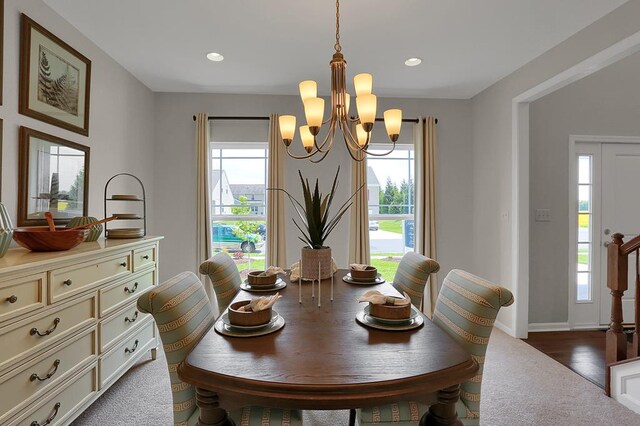 dining space featuring wood-type flooring, a wealth of natural light, and an inviting chandelier