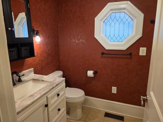 12 Justis St, Onancock, VA 23417 - half bathroom featuring toilet, vanity, tile patterned flooring, and baseboards