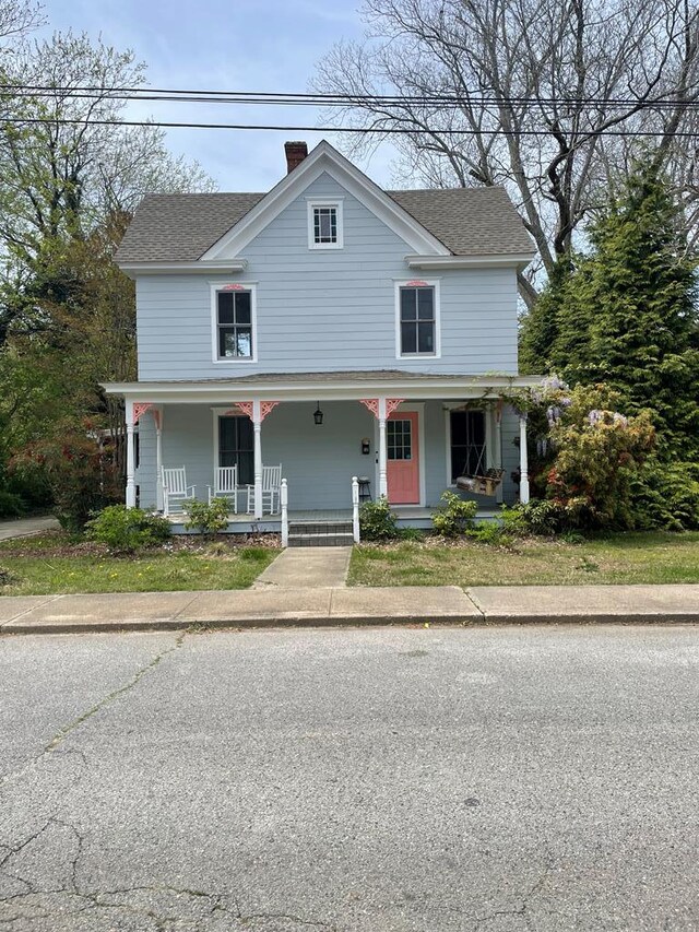 12 Justis St, Onancock, VA 23417 - view of front of home with a shingled roof, covered porch, and a chimney