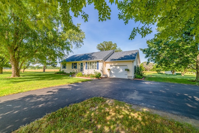 ranch-style house featuring a front lawn, aphalt driveway, and an attached garage