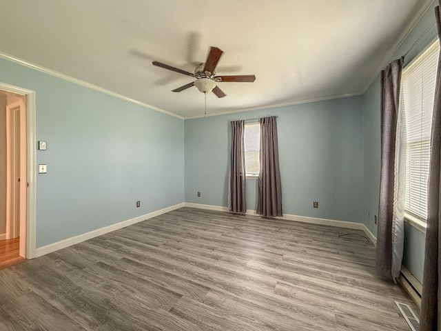 unfurnished room featuring baseboards, crown molding, wood finished floors, and ceiling fan