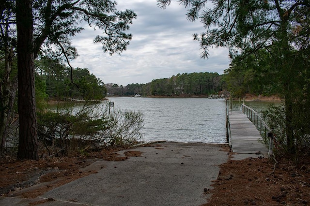 dock area featuring a water view and a view of trees