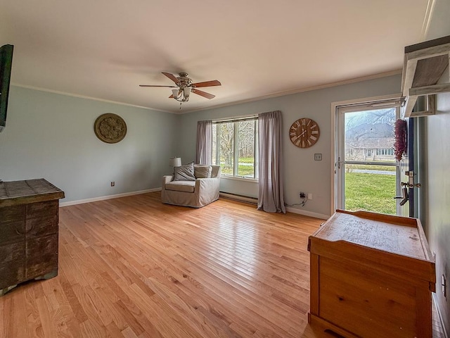 sitting room featuring a baseboard radiator, a ceiling fan, ornamental molding, and light wood-type flooring