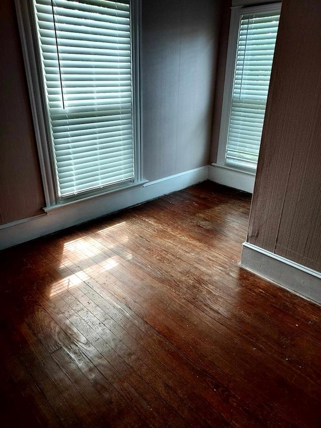 empty room with dark hardwood / wood-style flooring