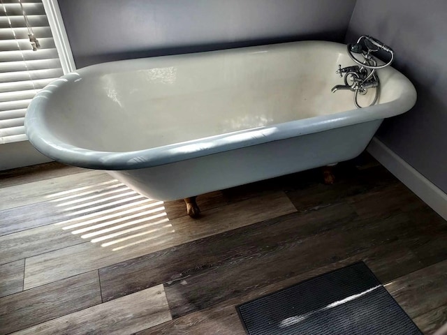 bathroom with wood-type flooring and a tub