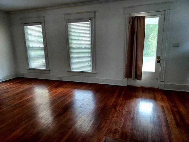 spare room with a healthy amount of sunlight and dark hardwood / wood-style flooring