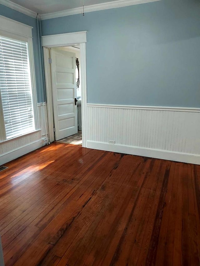 empty room featuring hardwood / wood-style flooring, a healthy amount of sunlight, and ornamental molding