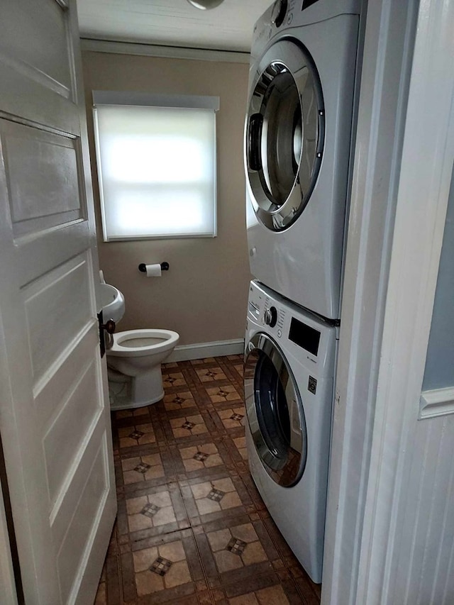clothes washing area with stacked washer / dryer