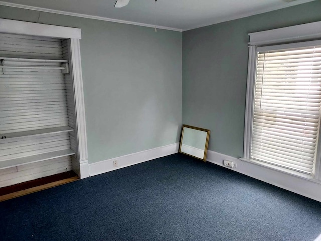 carpeted spare room featuring ceiling fan and crown molding