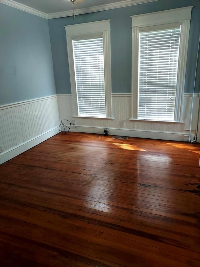 empty room featuring hardwood / wood-style flooring and ornamental molding