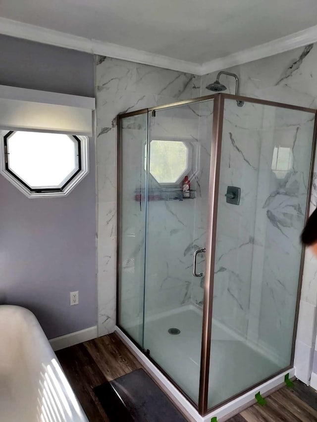 bathroom with hardwood / wood-style floors, crown molding, and independent shower and bath