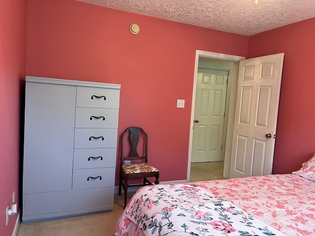 bedroom featuring a textured ceiling and light colored carpet