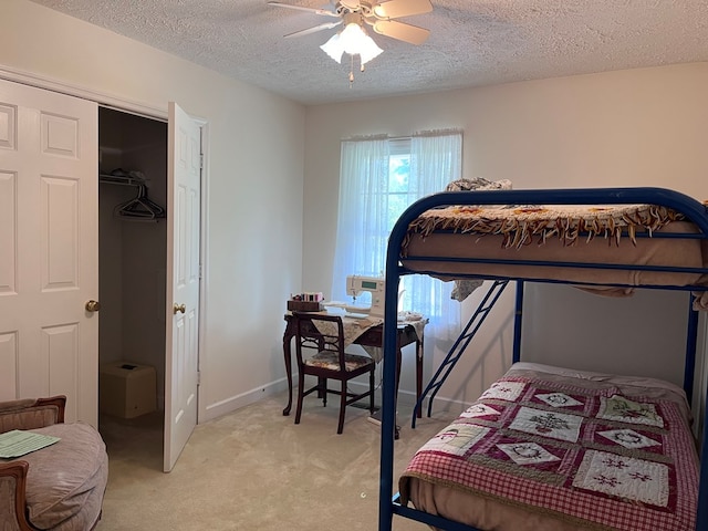 bedroom featuring light carpet, ceiling fan, and a textured ceiling