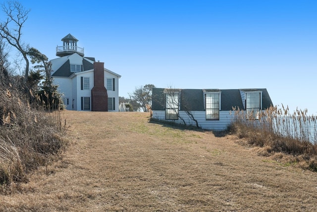 view of side of home with a balcony and a yard