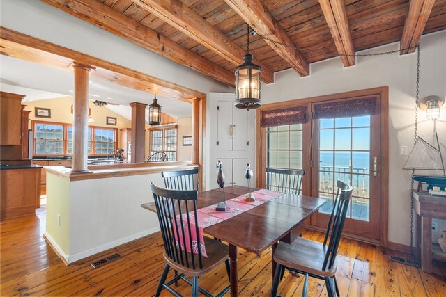 dining area with ornate columns, beam ceiling, a water view, wooden ceiling, and light hardwood / wood-style floors