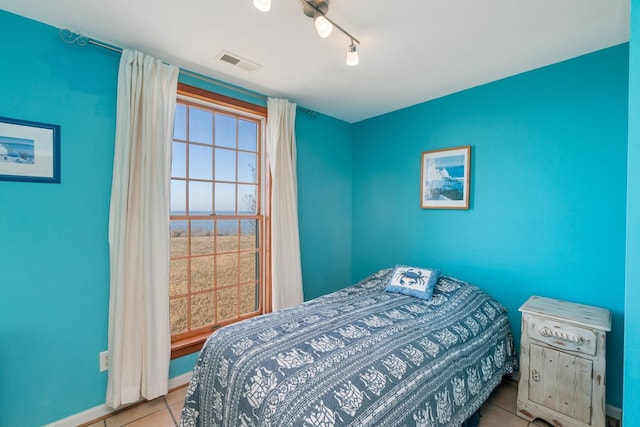 bedroom featuring ceiling fan, light tile patterned floors, and track lighting