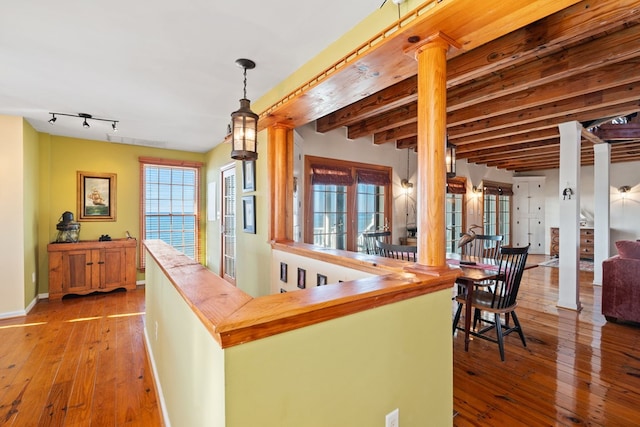 interior space featuring beam ceiling, pendant lighting, and light wood-type flooring