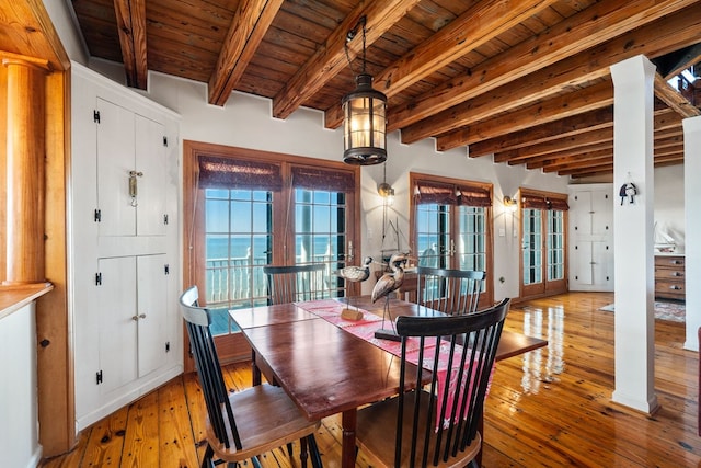 dining space featuring beam ceiling, light hardwood / wood-style floors, and french doors