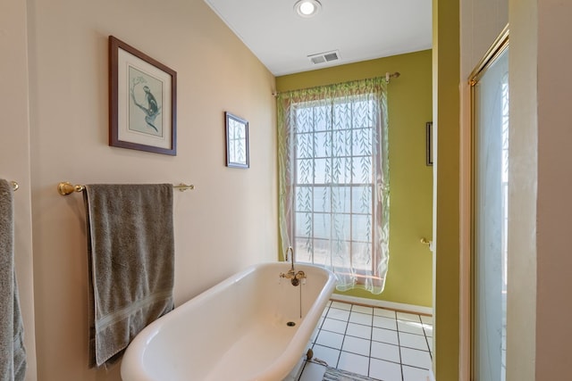 bathroom featuring tile patterned floors and a tub to relax in