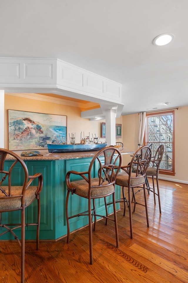 bar featuring white cabinetry and hardwood / wood-style flooring