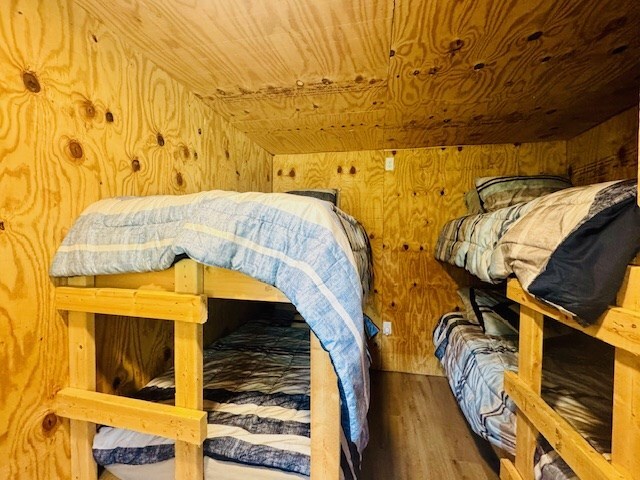 bedroom featuring wood ceiling, wood walls, and wood finished floors