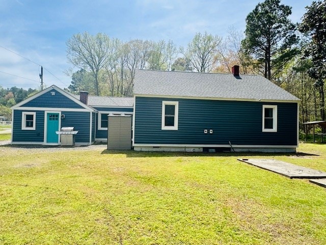 rear view of property featuring a lawn and a chimney
