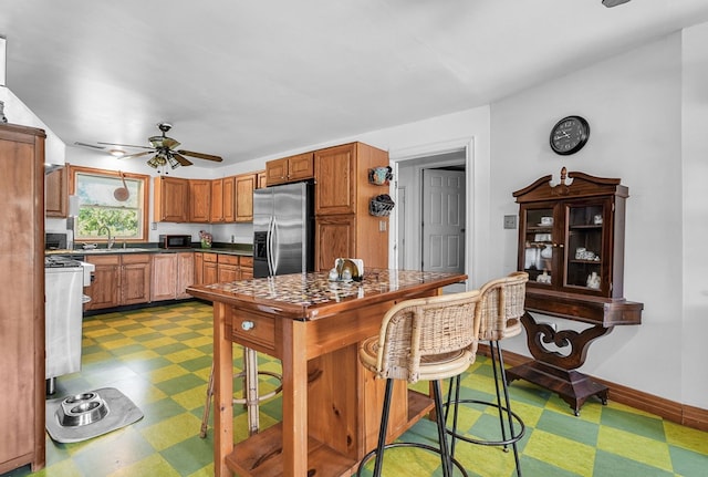28099 Harborton Rd, Harborton, VA 23389 - kitchen featuring stainless steel fridge with ice dispenser, light floors, range, ceiling fan, and dark countertops