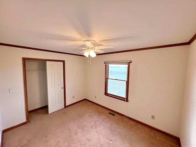 unfurnished bedroom with ceiling fan, a closet, and light carpet