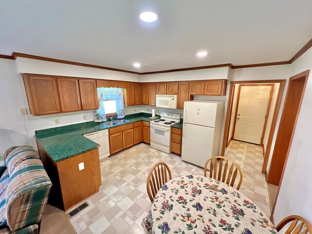 kitchen featuring white appliances, ornamental molding, and sink