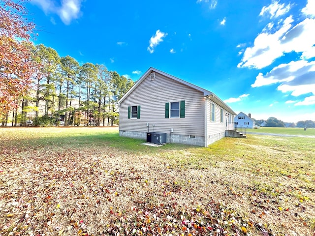 view of property exterior featuring central AC and a yard