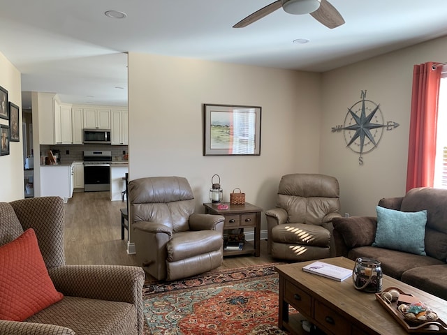 living room with ceiling fan, a healthy amount of sunlight, and dark hardwood / wood-style flooring