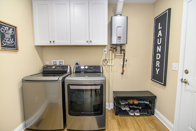 2265 Yardarm Dr, Greenbackville, VA 23356 - clothes washing area featuring washing machine and clothes dryer, cabinet space, baseboards, tankless water heater, and wood finished floors