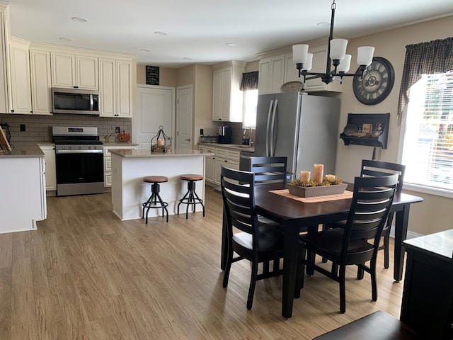 dining room with a notable chandelier, light hardwood / wood-style floors, and sink