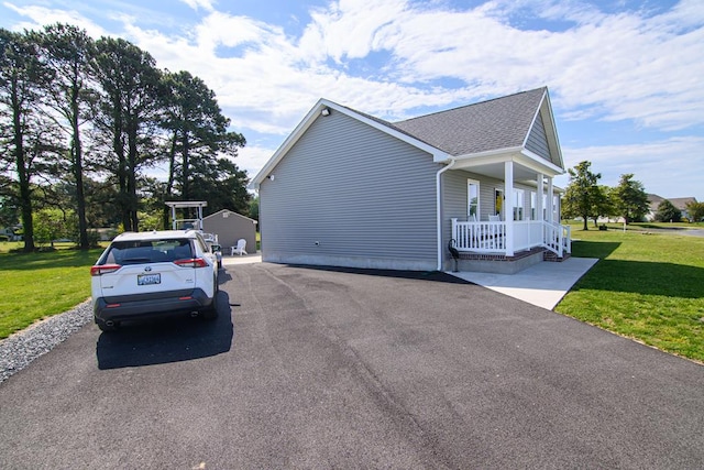 2265 Yardarm Dr, Greenbackville, VA 23356 - view of side of property featuring a porch, a yard, and a shingled roof