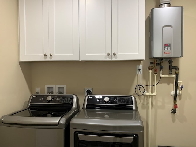 laundry area with separate washer and dryer, cabinets, and tankless water heater