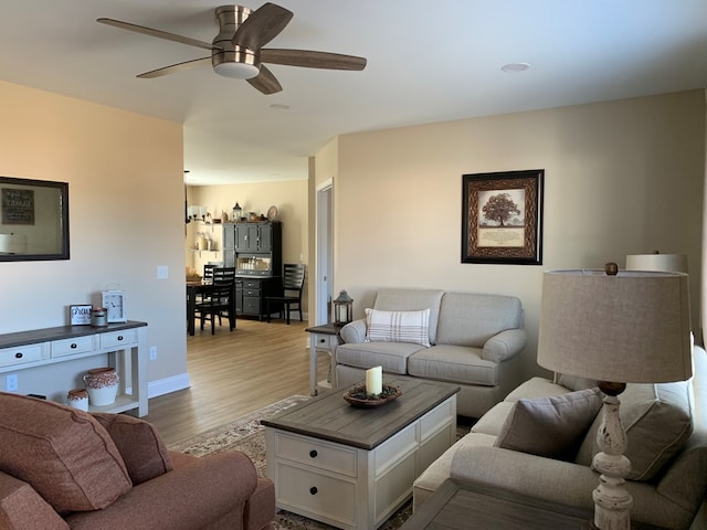 living room with ceiling fan and light hardwood / wood-style flooring