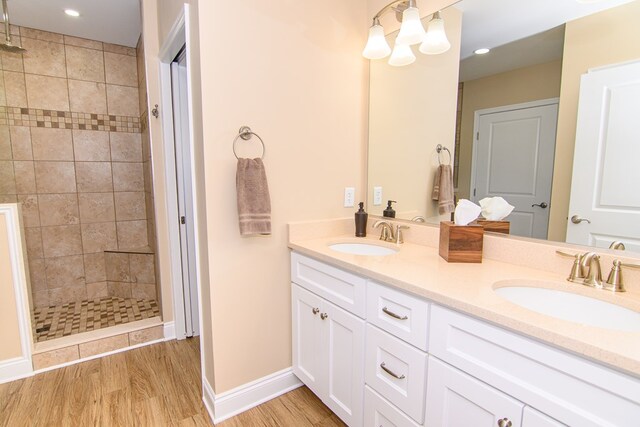 2265 Yardarm Dr, Greenbackville, VA 23356 - bathroom featuring double vanity, a sink, wood finished floors, and tiled shower