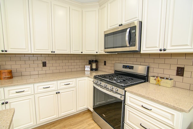 2265 Yardarm Dr, Greenbackville, VA 23356 - kitchen featuring light wood-style floors, decorative backsplash, light stone countertops, and stainless steel appliances