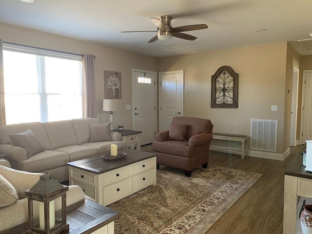 living room featuring ceiling fan and dark wood-type flooring