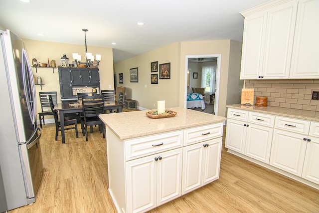 2265 Yardarm Dr, Greenbackville, VA 23356 - kitchen featuring tasteful backsplash, freestanding refrigerator, light wood finished floors, and white cabinets