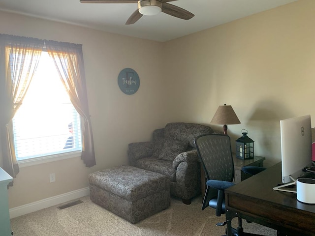 office space with ceiling fan, a healthy amount of sunlight, and light carpet