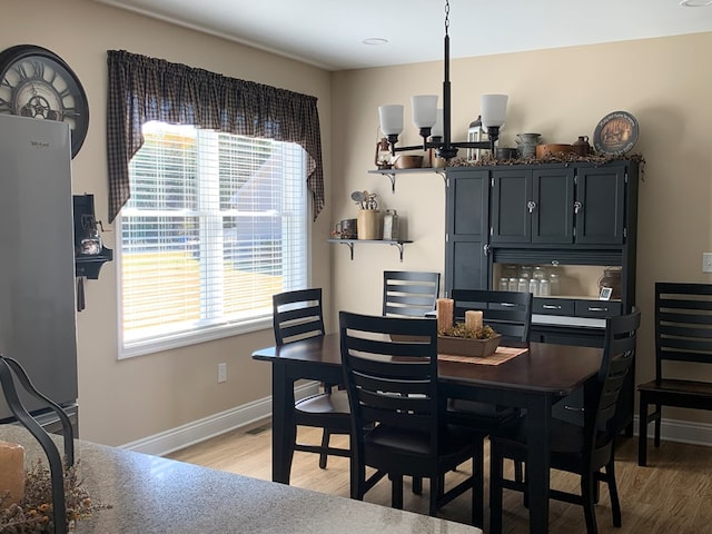 dining room featuring a chandelier, a wealth of natural light, and light hardwood / wood-style flooring