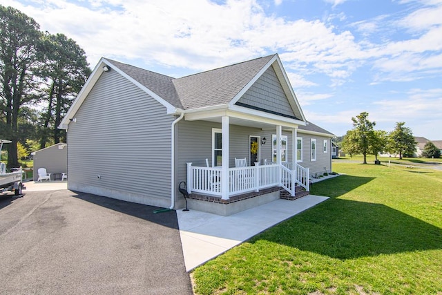 2265 Yardarm Dr, Greenbackville, VA 23356 - view of property exterior with a shingled roof, a yard, and a porch