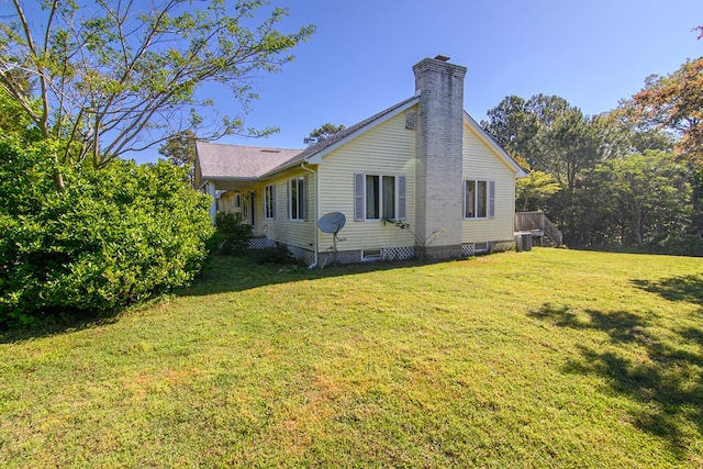 24324 Adams Hill Dr, Accomac, VA 23301 - view of home's exterior featuring a chimney, central AC, and a lawn